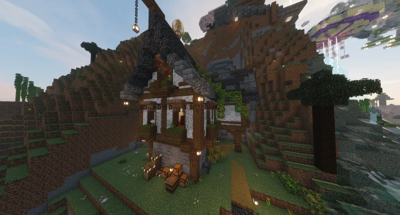 Средневековый деревянно-каменный домик в Minecraft на склоне горы с фонарями